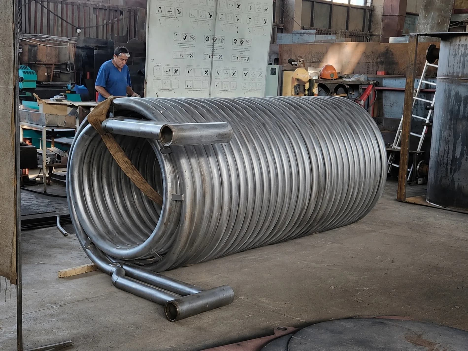 Worker beside a wound coil before installation